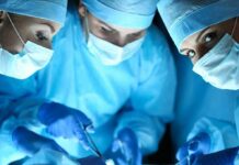How A Cesarean Birth Is Actually Done surgeons in blue scrubs performing an operation
